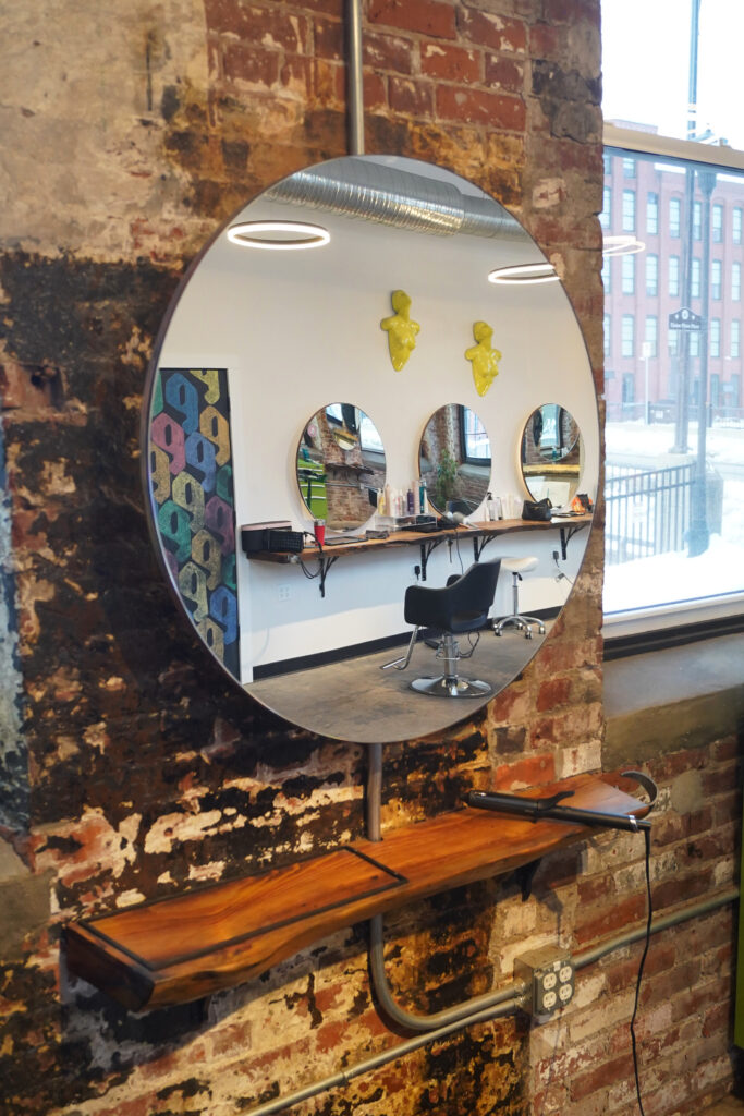 Round mirrors at salon stations reflecting off each other.