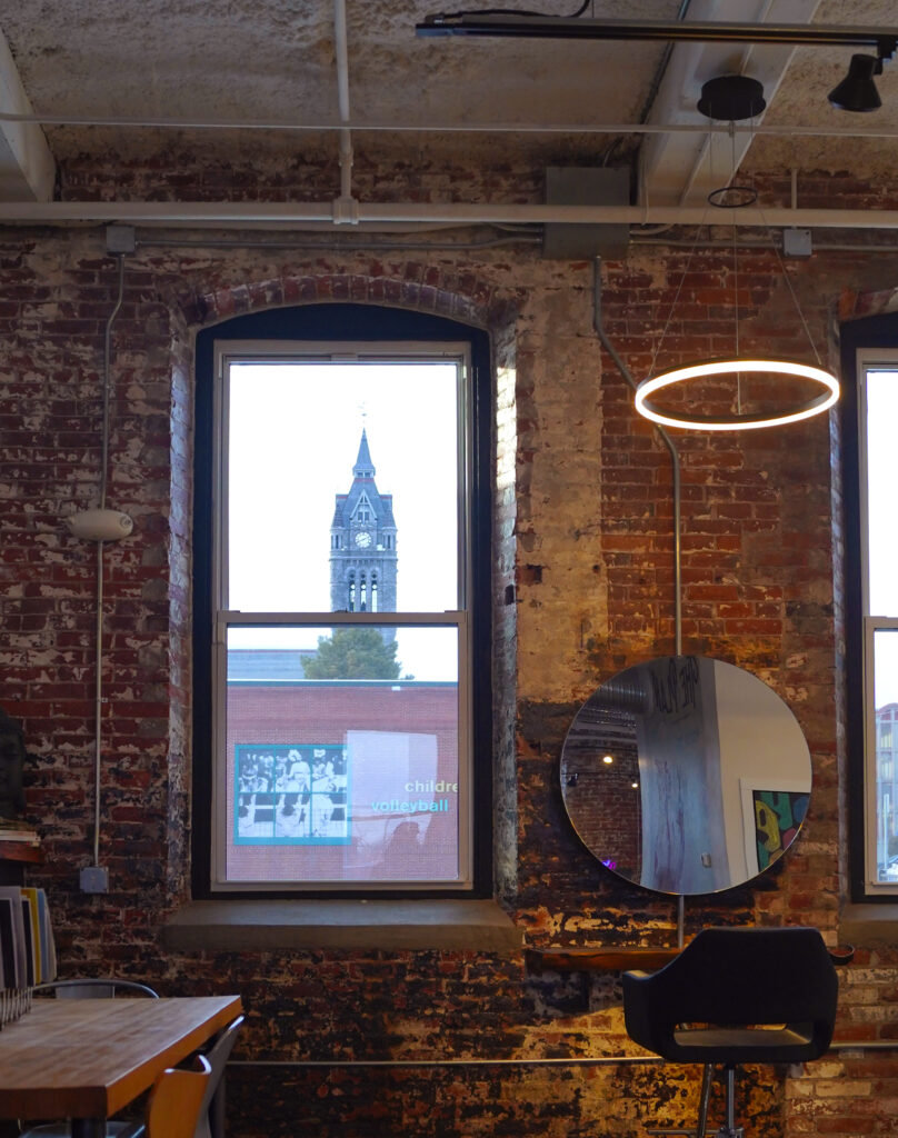 Interior shot out the window highlighting church steeple nearby.